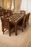 Wooden dining table with colorful ceramic tile top and six chairs